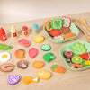 A collection of colorful wooden salad pretend play food items including vegetables and fruit on a light wooden surface.