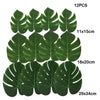 Twelve artificial tropical palm leaves in various sizes and shades of green for party decor