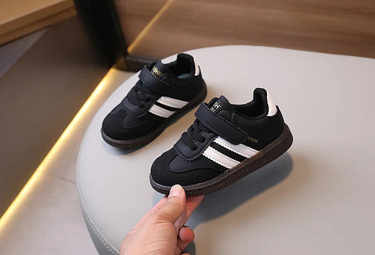 A pair of black and white casual sneakers resting on a light surface.