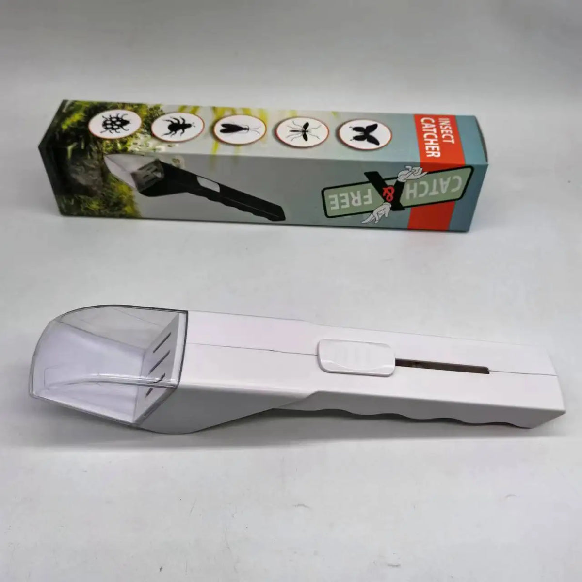 A white handheld insect catcher with a clear lens and a black handle is shown next to its retail box.