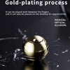 A gold-plated metal fidget spinner resting on a dark marble surface.