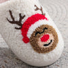 A white plush indoor slipper decorated with a brown reindeer face and a red Santa hat.