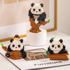 A mini panda building block set featuring black and white figures with brown accents displayed on a white stand.