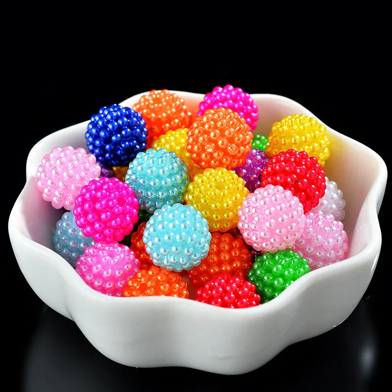 A bowl filled with various brightly colored acrylic pearl beads for jewelry making