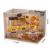 A wooden miniature dollhouse kit featuring a cafe shop interior with furniture and display items.