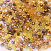 A pile of faceted crystal bicone glass beads in various shades of amber and brown for jewelry making