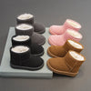 A collection of cozy fur-lined winter boots in shades of pink, brown, and gray displayed on a light surface.