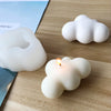 White cloud-shaped silicone mold for candle, soap, or jewelry making resting on a wooden surface.