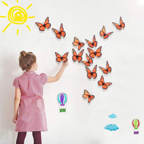 Orange monarch butterflies and a yellow sun are displayed on a white wall.