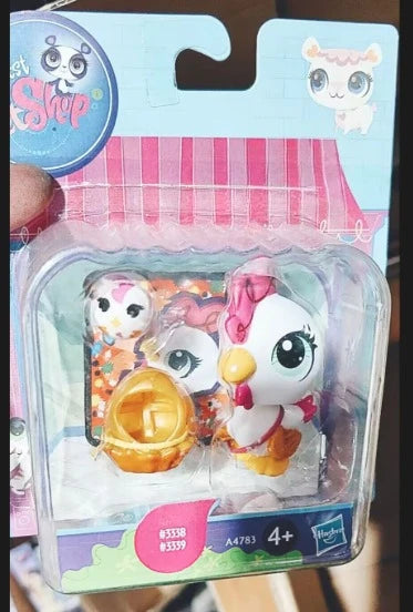 A clear plastic package containing three small white and pink animal figures for sale.