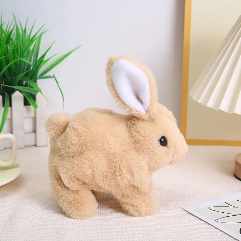 A light brown plush rabbit toy with white inner ears sitting on a white surface.