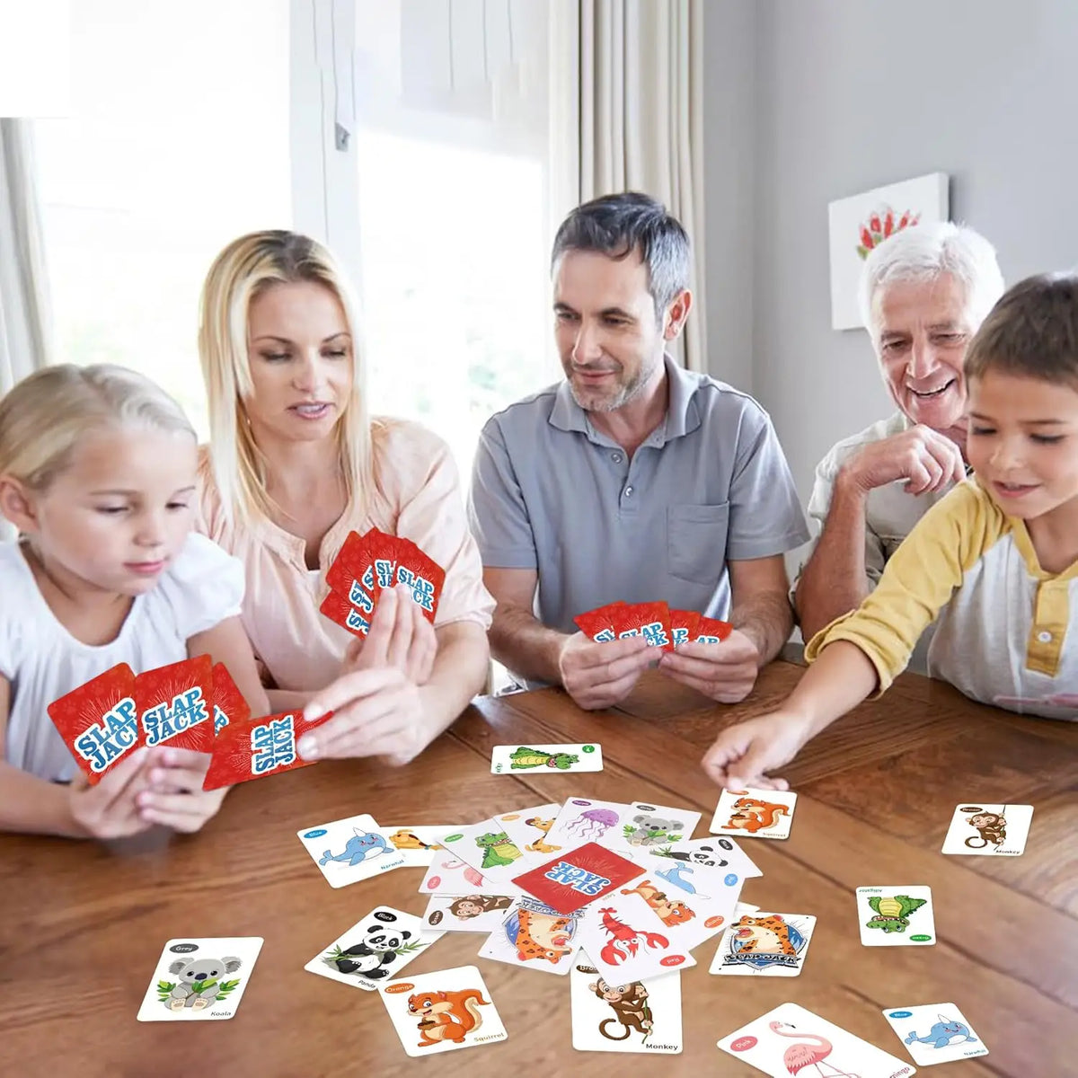 A family playing an animal and nature card game around a wooden table with various cards.