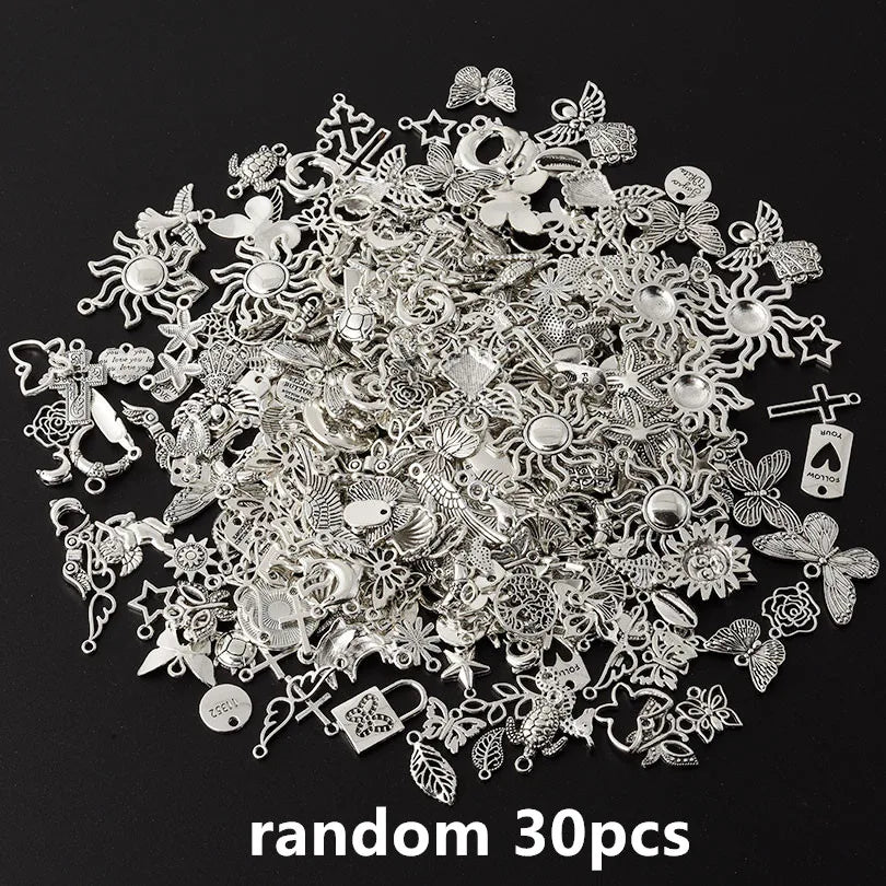 A pile of random silver and gold metal charms for DIY jewelry making
