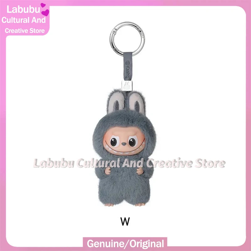 A small gray plush doll resembling a rabbit with long ears is attached to a silver keychain ring.