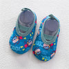 A pair of blue and yellow baby barefoot water shoes with colorful cartoon characters