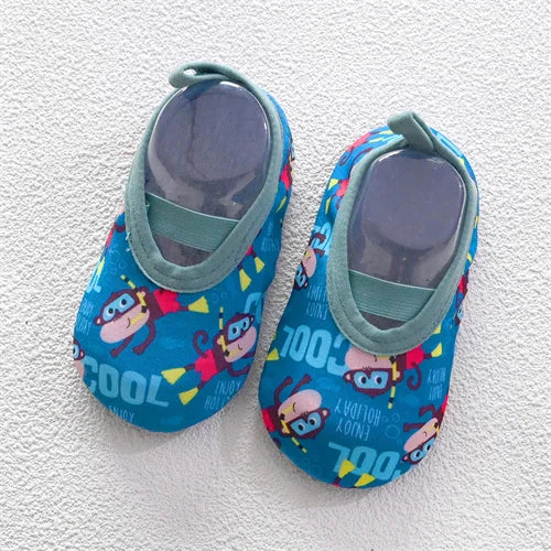 A pair of blue and yellow baby barefoot water shoes with colorful cartoon characters