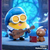 A POP MART Minions Bedtime Stories collectible figure with large goggles playing an acoustic guitar.