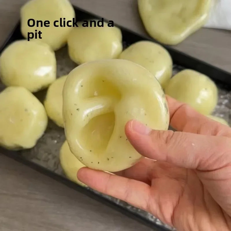 A hand is squeezing a yellow mashed potato squeeze toy stress reliever, showing its texture and shape.