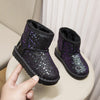 A pair of purple glitter snow boots with faux fur lining resting on a white surface.
