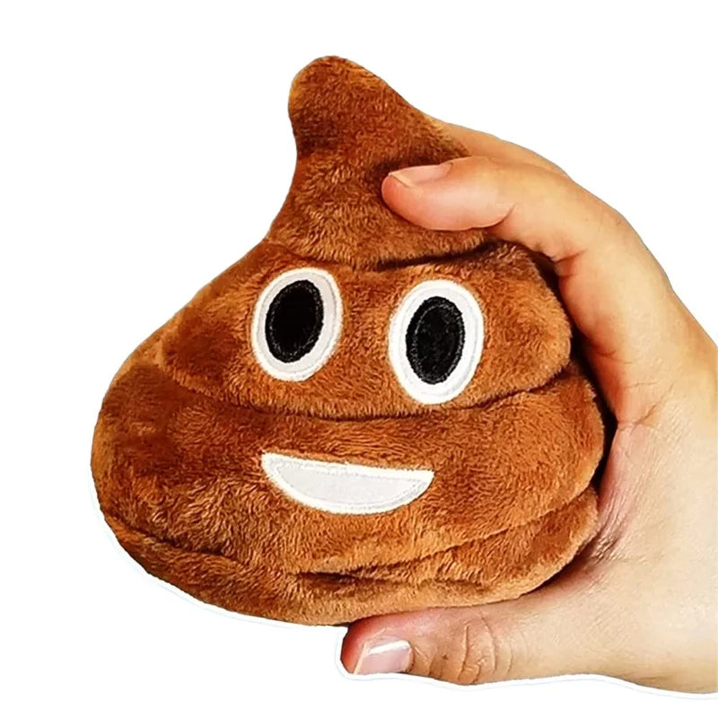 A hand is holding a brown, squishy-looking plush toy shaped like a poop with white facial features.