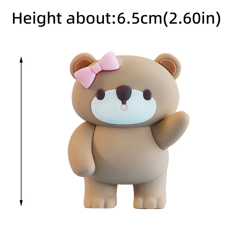 A cute, light brown bear-shaped cake topper with pink ears and a bow.