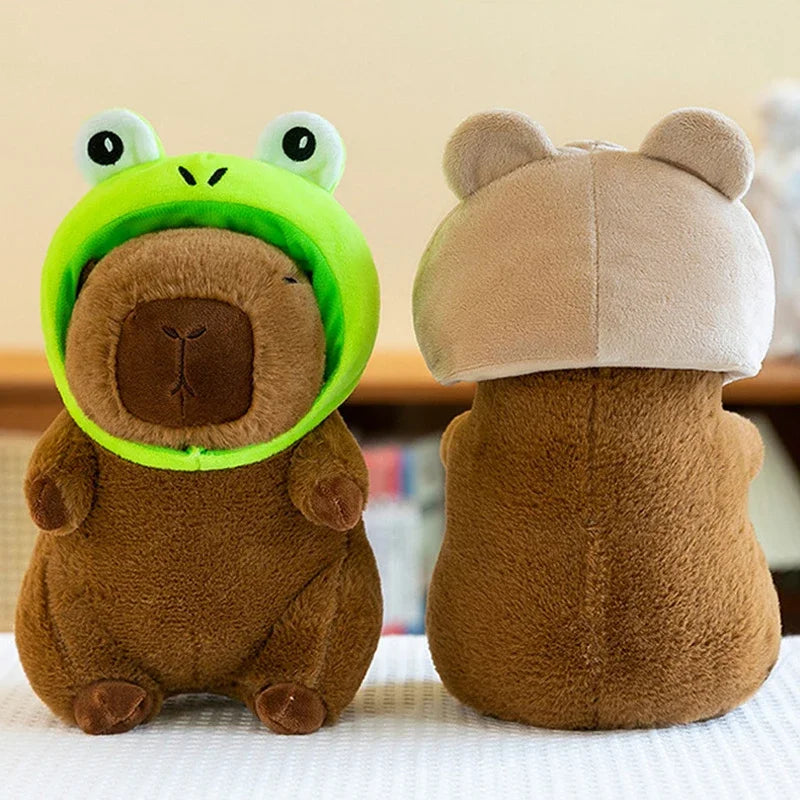 A soft brown capybara plush toy wearing a light beige hat and bright green ear coverings.