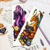 A craft kit featuring a purple and gold dragon bookmark design for cross-stitching