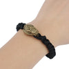 Brass snake head bead attached to a black paracord lanyard worn on a wrist.