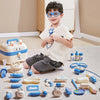 A child is holding a kids doctor play set with various medical tools and a stethoscope on a light-colored carpet.