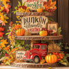 A tiered display featuring pumpkins, autumn leaves, and rustic wooden signs for a diamond painting kit.