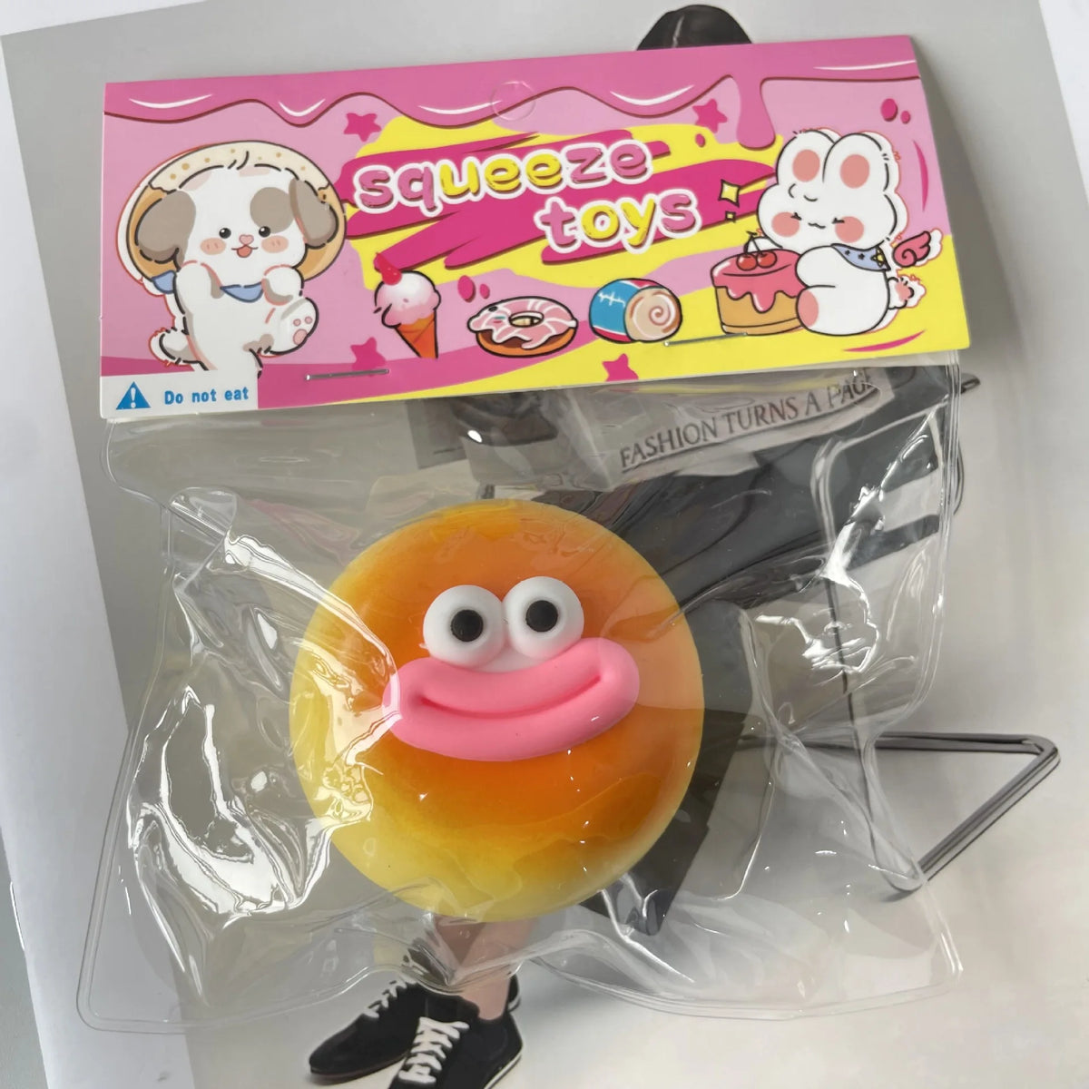 A yellow squishy toy shaped like a piece of toast with pink accents is visible in clear plastic packaging.