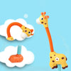 A yellow giraffe spray water toy with an orange flexible tube and a blue nozzle, shown next to white clouds.