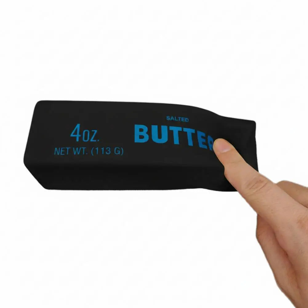 A hand holds a black salted butter stick fidget toy with the label 4oz and butter writing on it.