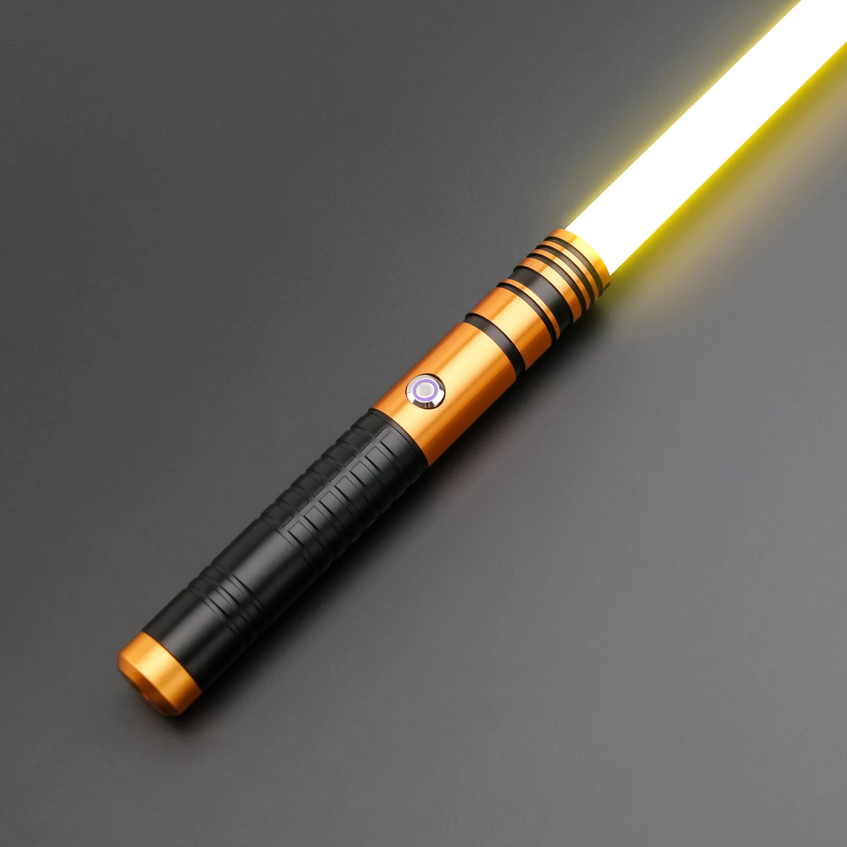 A glowing yellow lightsaber toy with a metallic handle and battery is shown against a dark gray background.