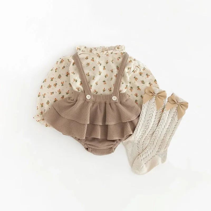 A vintage floral baby girl outfit set featuring a blouse and romper with beige and cream tones.