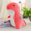 A soft pink and white triceratops plush dinosaur toy lying on a white surface.