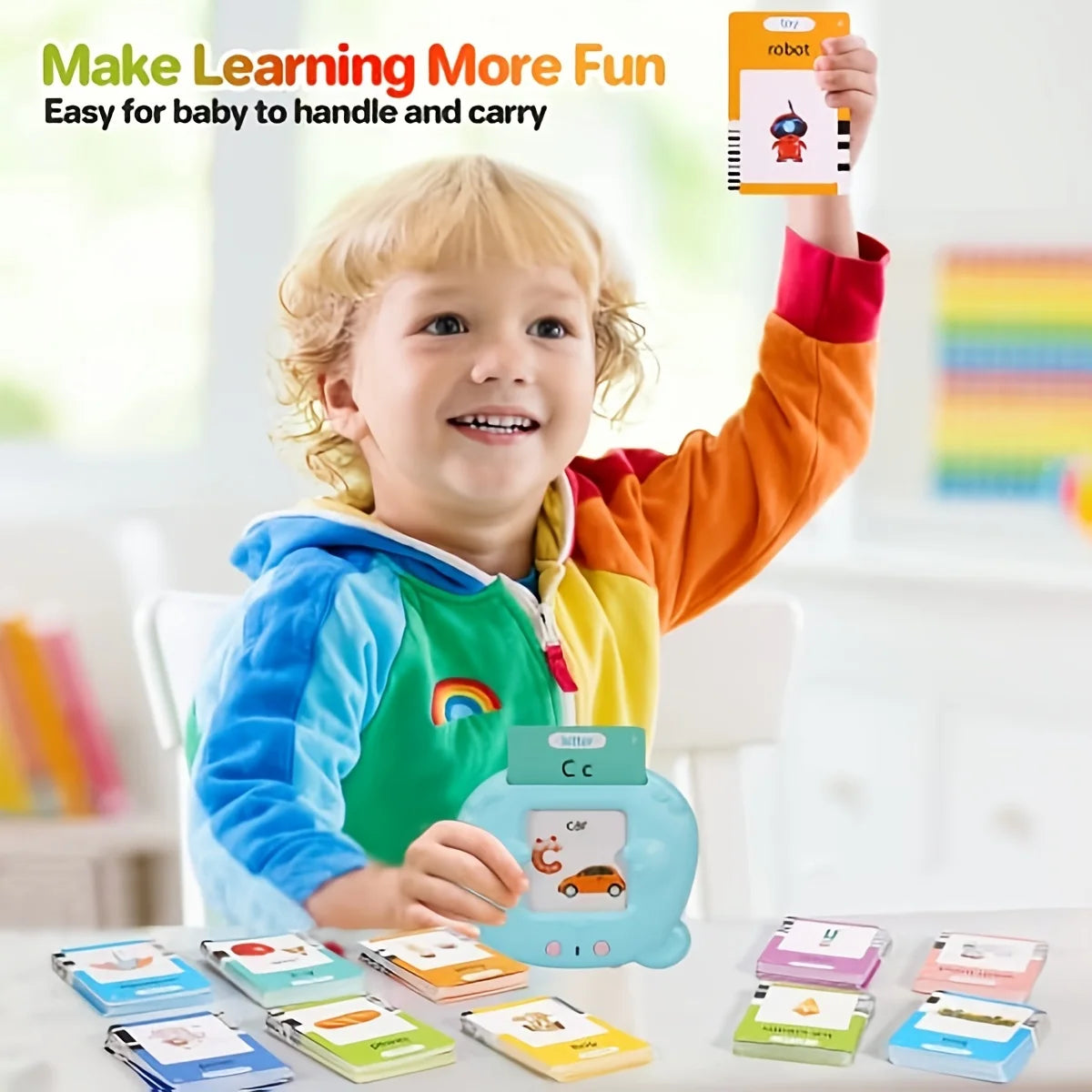 A smiling toddler holds up a learning machine with flash cards and a robot toy in a bright indoor setting.