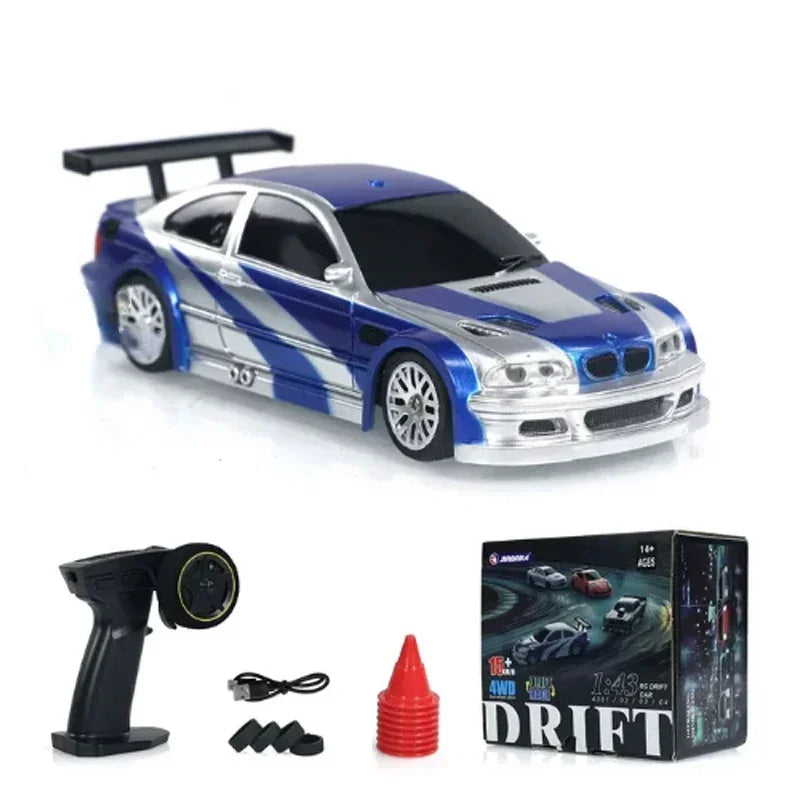 A blue and silver mini RC drift car with a black roof and spoiler, shown next to its remote control and accessories.