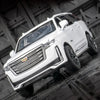 A white 1:32 scale diecast Cadillac Escalade pull-back model car is shown in a dynamic angle.