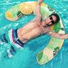 A man is floating on a yellow inflatable U-shaped swim ring in clear blue water.