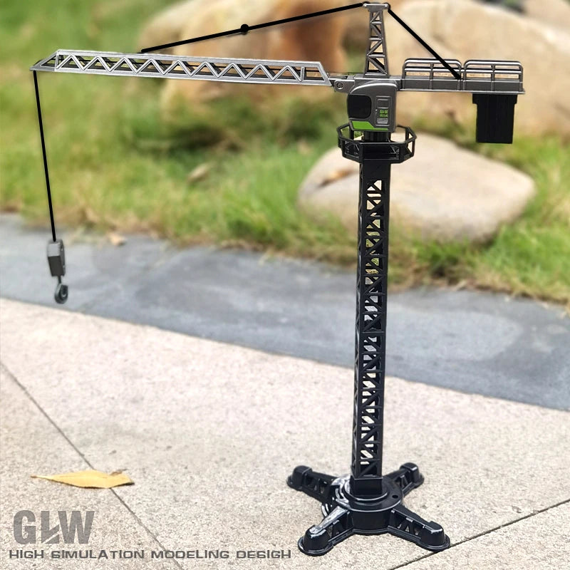 A silver diecast construction crane model toy set mounted on a black stand, set against a blurred outdoor background.