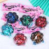 A collection of pink and iridescent squishy fidget toys shaped like cat paws for stress relief and sensory play