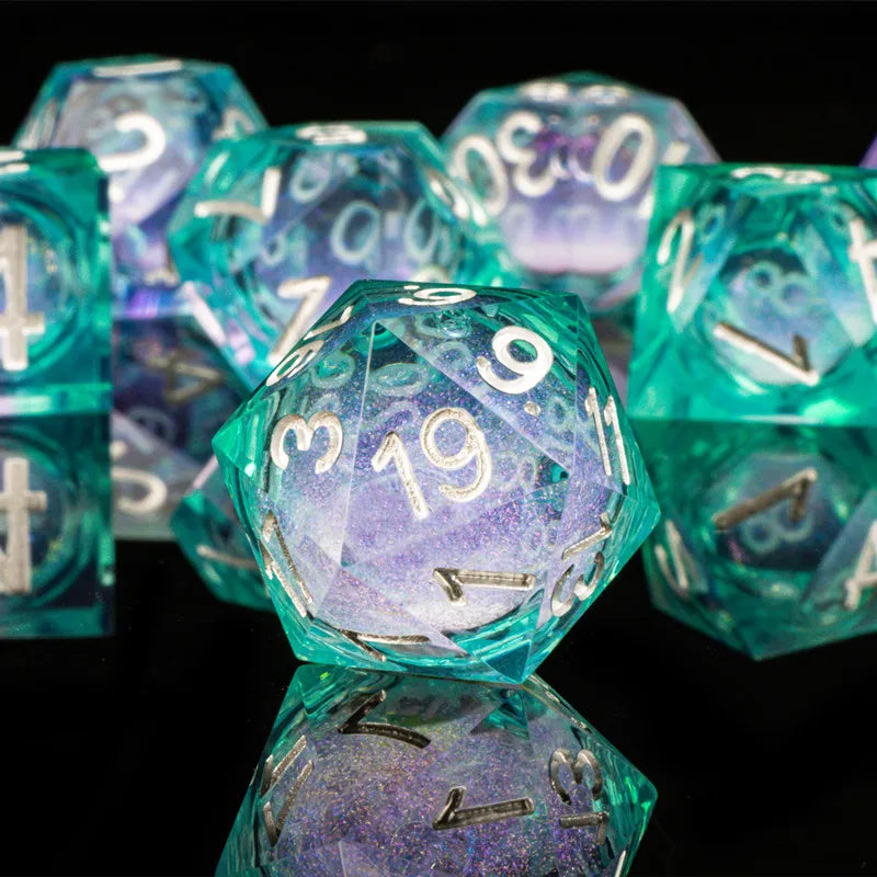 A close-up of a set of iridescent teal and purple liquid core dice used for tabletop gaming.