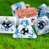 A set of polyhedral dice featuring a mushroom theme, resting on green grass.