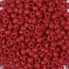 A close-up view of a 100-pack of small, round, red pony beads for jewelry making and craft projects.