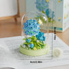 A clear glass jar filled with green flower building blocks and blue flowers.