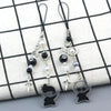 Anime-inspired keychain featuring black and white charms on a checkered fabric background