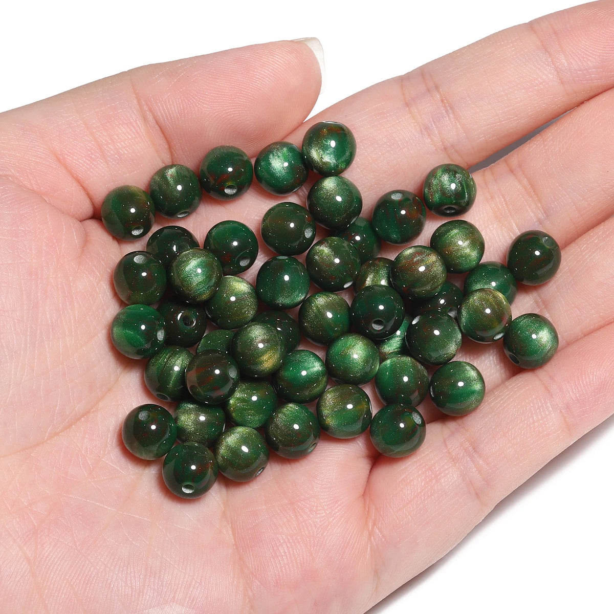A handful of small, dark green tiger eye resin beads for jewelry making