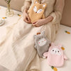 A person is holding a fluffy, light brown plush toy in their lap while wearing a cream-colored dress.