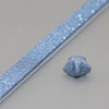 A close-up view of a light blue glitter paper strip and a small piece of folded origami star paper.